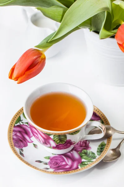 Taza de té con tulipanes rojos sobre blanco — Foto de Stock