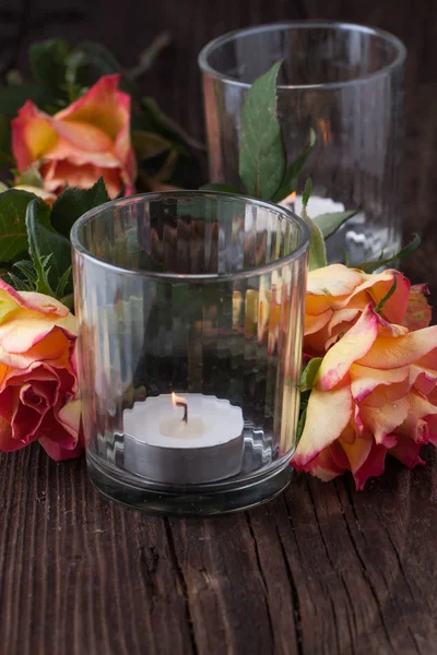 Orange roses with lightning candle — Stock Photo, Image