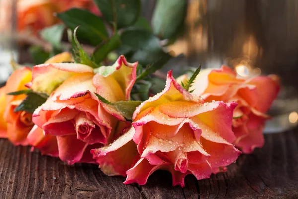 Pomarańczowe róże na stole — Zdjęcie stockowe