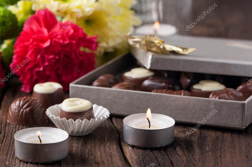 Caramelos de chocolate, velas y flores: fotografía de stock © NatashaBreen  #20097369 | Depositphotos