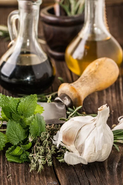 Oil and vinegar, gralic, knife and herbs — Stock Photo, Image