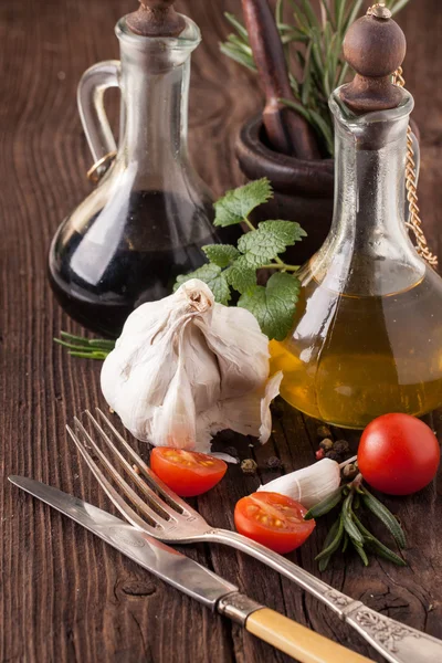 Oil and vinegar, gralic and tomatoes with herbs — Stock Photo, Image