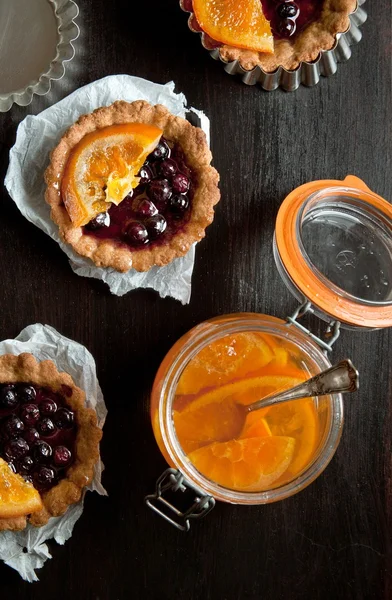 Sweet tartlets with jar of jam — Stock Photo, Image