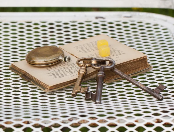 Vintage clocks and keys on book — Stock Photo, Image