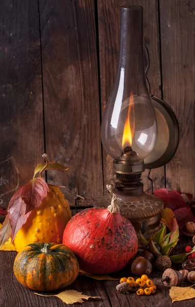 Старая лампа с тыквами, желудями и листьями — стоковое фото