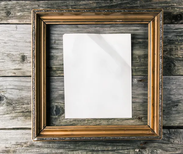 Vintage frame with paper on old wooden background — Stock Photo, Image