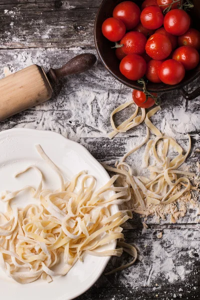 Raw homemade pasta with tomatoes — Stock Photo, Image