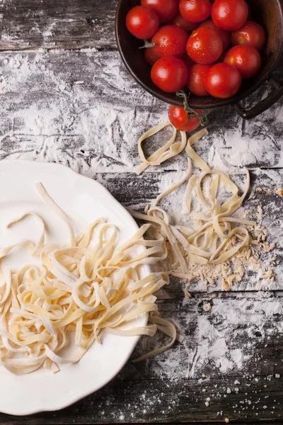 Raw homemade pasta with tomatoes — Stock Photo, Image