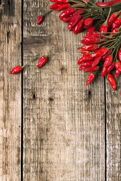 Red hot chili peppers over wooden background — Stock Photo, Image
