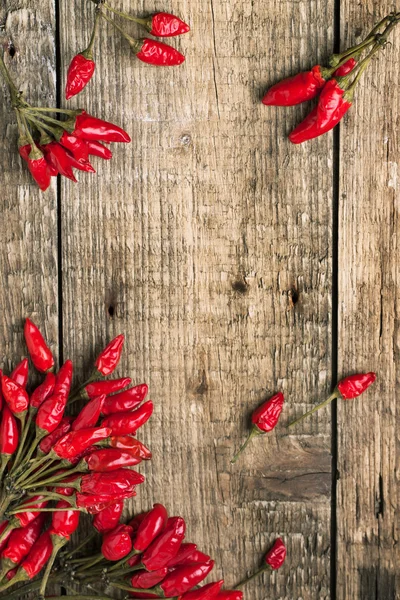 Wooden background with red hot chili peppers — Stock Photo, Image