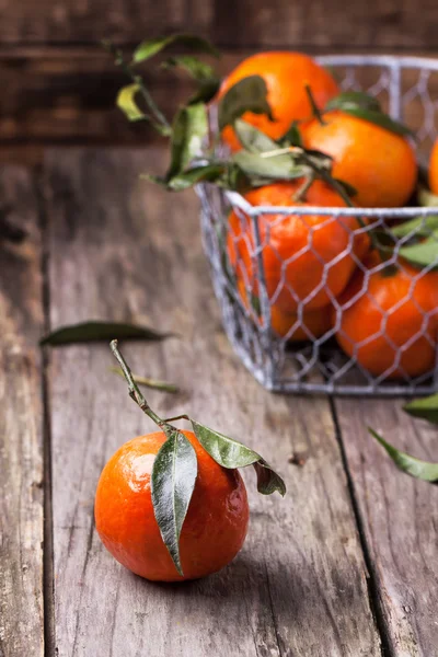 Tangeriner med blad på trä bakgrund — Stockfoto