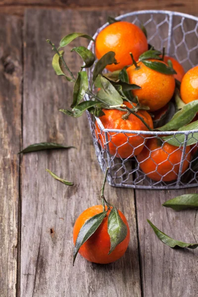 Tangerines with leaves on wooden background — Stock Photo, Image