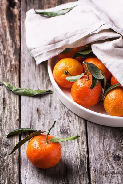 Tangeriner med blad på trä bakgrund — Stockfoto