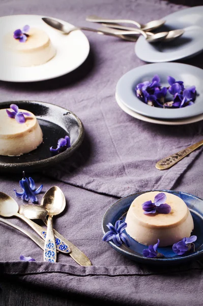Caramel pannacotta with violet flowers