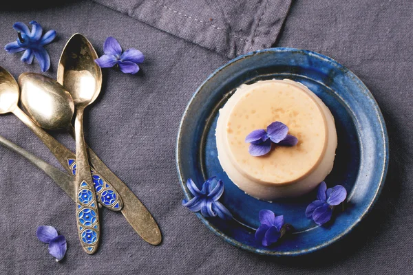 Pannacotta de caramelo com flores violetas — Fotografia de Stock