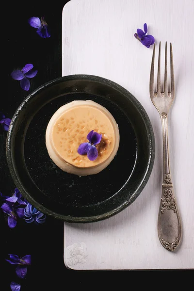 焦糖 pannacotta 与紫罗兰色的花朵 — 图库照片