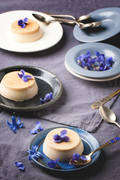 Caramel pannacotta with violet flowers — Stock Photo, Image