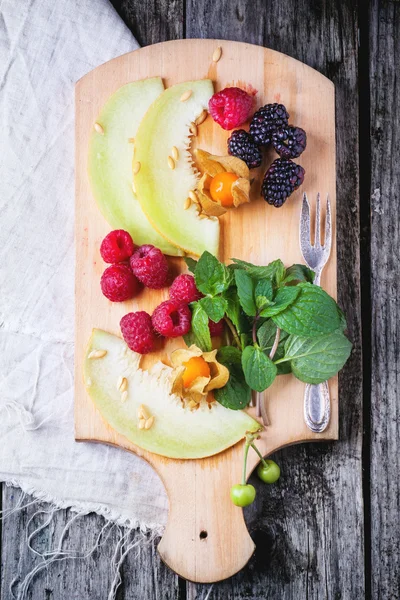 딸기, 박하와 나무 절단 보드에 멜론 — 스톡 사진