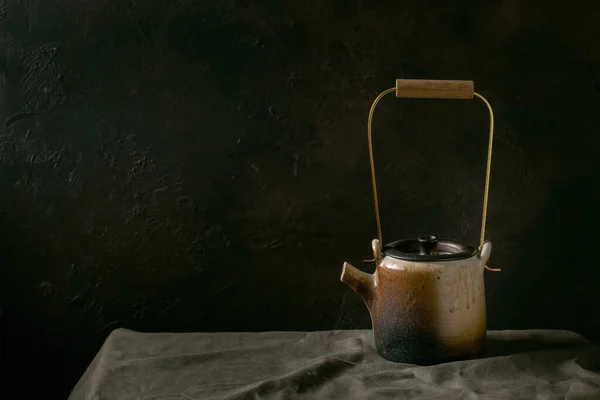茶道用手工制茶壶水壶 茶道用黄铜柄 放在深色房间的亚麻布桌布上 — 图库照片