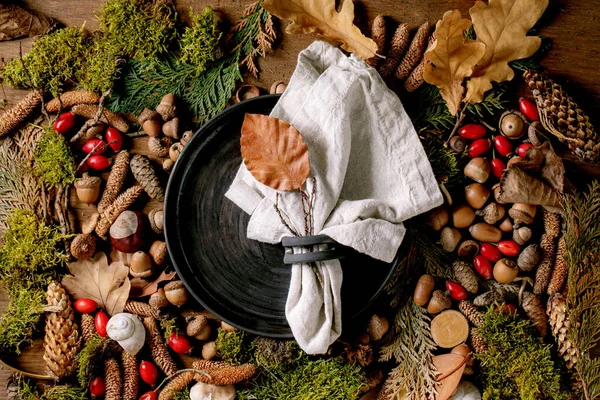 清澈的黑色陶瓷盘 布餐巾盖在氛围神奇的秋天森林背景之上 秋天的叶子 蜗牛壳覆盖在木制表面 秋季感恩节菜单 平躺在床上 — 图库照片