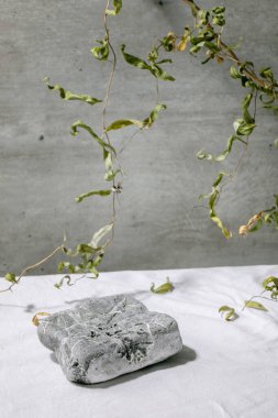 Podyum olarak geometrik kare taşlı soyut doğal sahne veya çiçek desenli beyaz tekstil ürünleri sunumu veya sergisi için kaidesi. Reklam için herhangi bir ürün gösterilecek sahne.