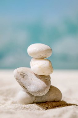 Yazın kumsal sahilinde dengeleyici bileşimlerde farklı boyutlarda beyaz pürüzsüz taşlar ve arka planda dalgalar. Uzay yaratım planını kopyala. Tatil dengesi kavramı.