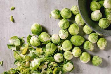 Kabuğu soyulmuş organik Brüksel lahanası seramik kasede küçük lahana filizleri açık gri arka planda kabuk soyar. Sebzeler sağlıklı beslenir. Düz yatıyordu. Kapat.