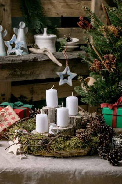 クリスマスファッション素朴なスタイルのインテリア装飾 Diy天然芝の花輪とテーブルの上のアドベントキャンドル 背景として古い木製のパレット上の陶器やギフトボックスを作成します トレンド 環境に優しい住宅デザイン — ストック写真