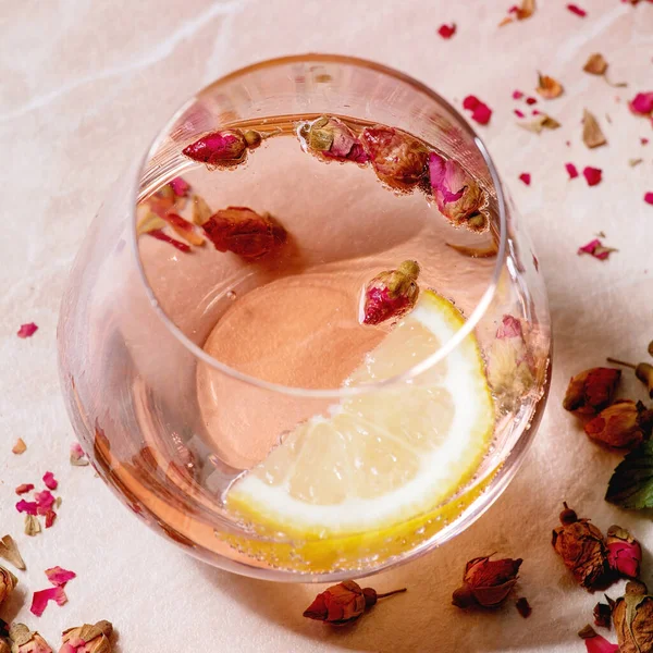 ピンクのバラのシャンパン サイダーまたはレモネードのカクテルグラスにドライローズの芽とレモン ピンクの大理石の背景 閉めろ 正方形の画像 — ストック写真