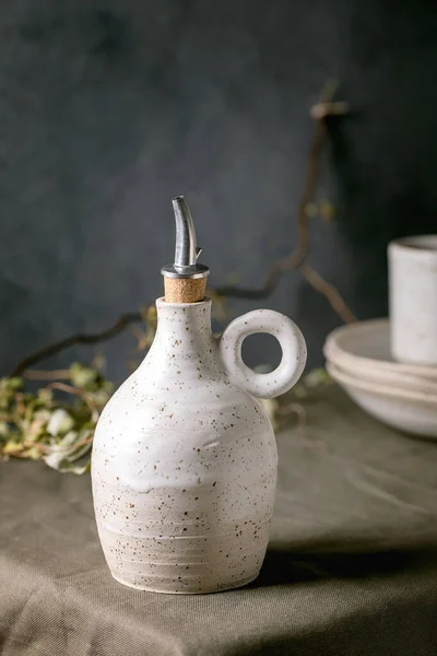 Weißgesprenkelte Craft Keramik Olivenöl Oder Essigflaschenspender Stehen Auf Dunkelgrüner Leinentischdecke — Stockfoto