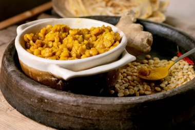 Roti ekmekli vegan dhal. Geleneksel Hint sarısı bezelye dalıyla Roti yassı ekmek, eski ahşap masada seramik kasede limonla servis ediliyor. Kapat.