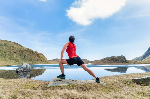 Kobieta Wykonuje Ćwiczenia Gimnastyczne Samodzielnie Pobliżu Górskiego Jeziora — Zdjęcie stockowe