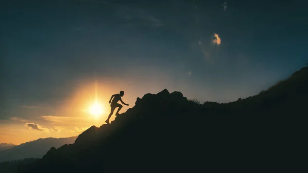 Silhouette Man Climbs Rocky Ridge Mountains Striking Colorful Sunset — Stok fotoğraf