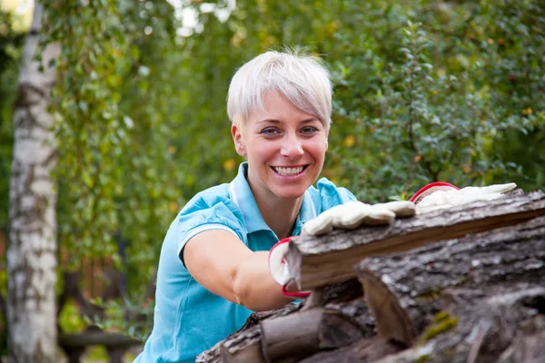 Frau mit Feuerholz — Stockfoto