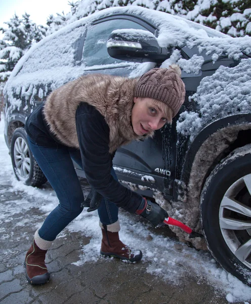 Woman cleans snow from car — Stock Photo, Image