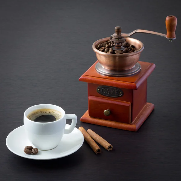 A cup of coffee and a coffee grinder — Stock Photo, Image