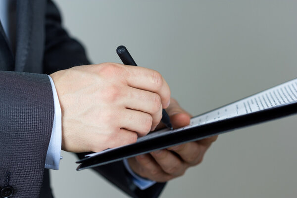 Close-up of business man signing documents