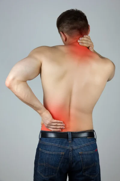 Young man touching his back and neck for the pain — Stock Photo, Image