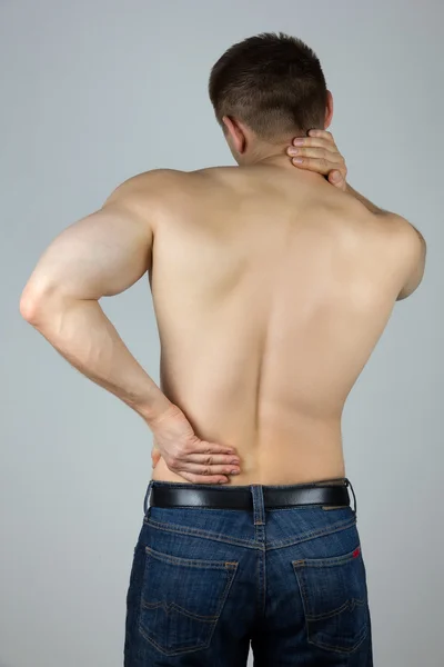 Joven tocándose la espalda y el cuello para el dolor — Foto de Stock