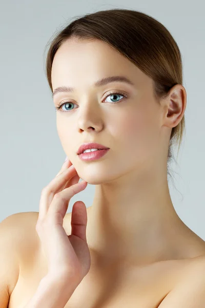 Beauty portrait of young woman touching her face — Stock Photo, Image