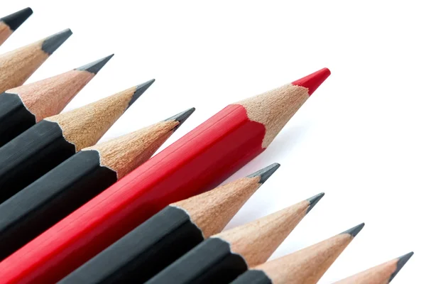 Row of black pencils with one red pencil in middle — Stock Photo, Image