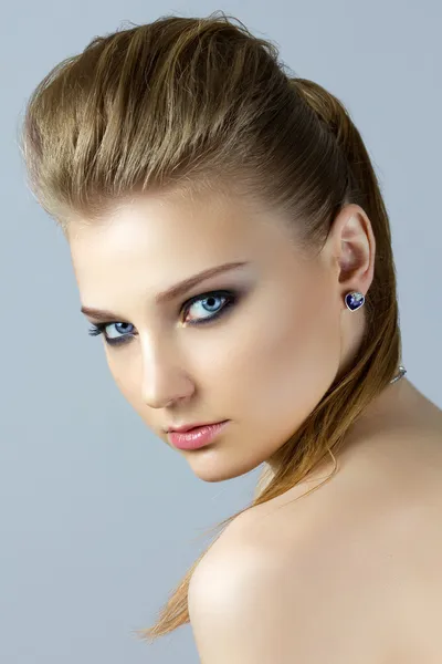 Portrait of young blonde woman looking over her shoulder — Stock Photo, Image