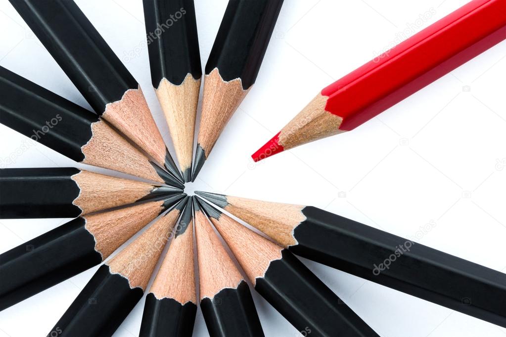 One red pencil standing out from the circle of black pencils