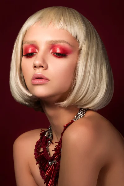 Retrato de moda de chica rubia joven sobre fondo rojo vino — Foto de Stock