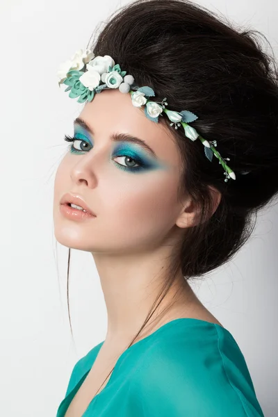 Portret van jonge brunette meisje in turkoois jurk met bloem d — Stockfoto