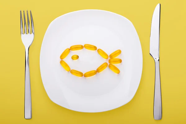 Fish oil soft gels lying on a plate — Stock Photo, Image