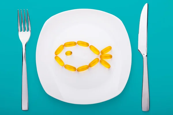 Fish oil soft gels lying on a plate Royalty Free Stock Photos