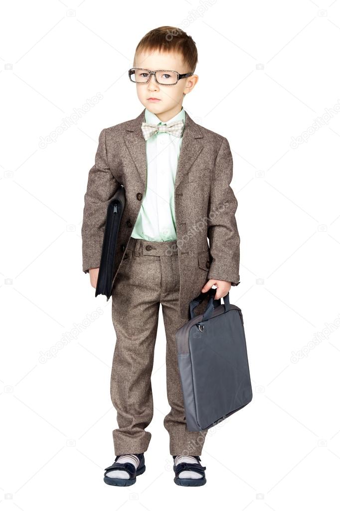 Young boy in grey suit and bow tie standing and looking on camer
