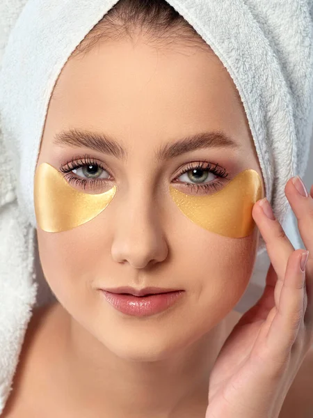 Mulher aplicando manchas olho de higrogel dourado — Fotografia de Stock