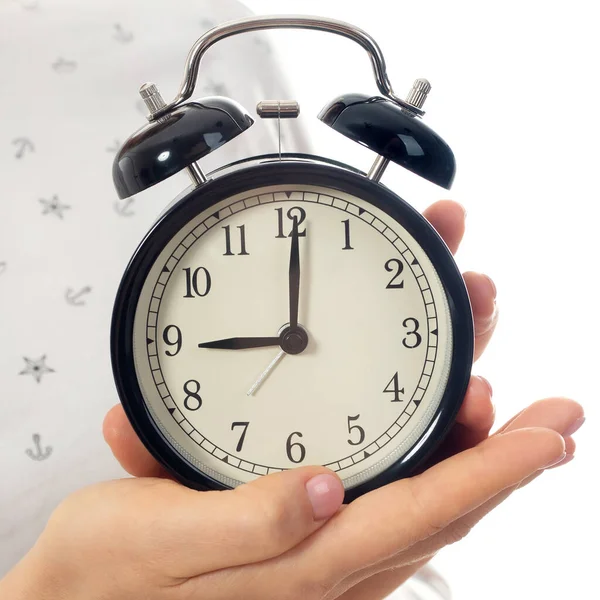 Woman hands holding black alarm clock — Stock Photo, Image